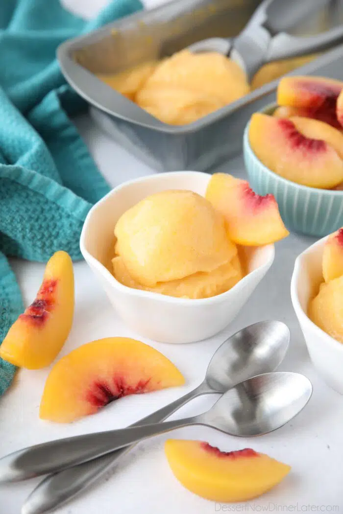 Peach Sorbet made with frozen peaches, sugar and lemon juice, scooped into a dish.