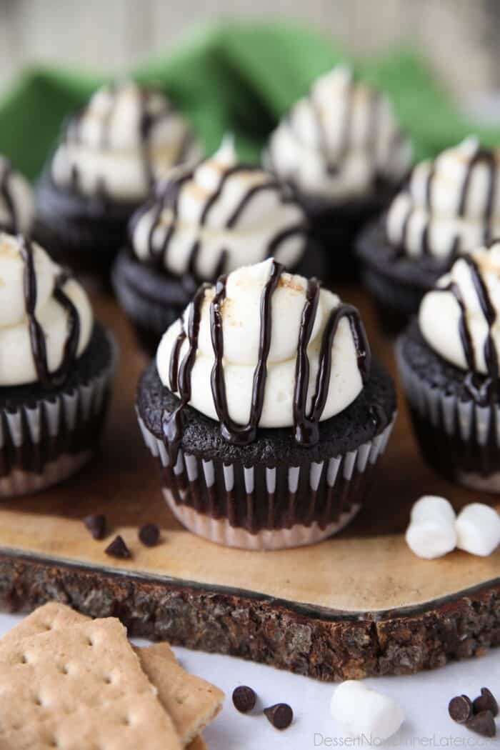ટોચ પર ઝરમર ઝરમર ચોકલેટ સોસ સાથે S'mores cupcakes.