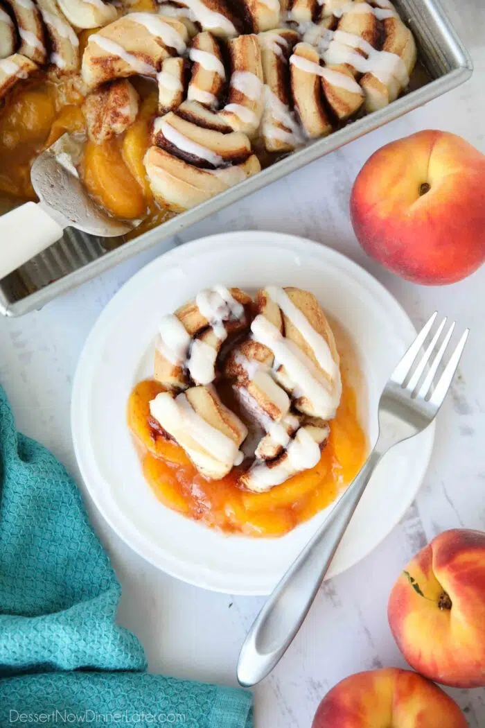 Cinnamon Roll Peach Cobbler on a plate with a fork.