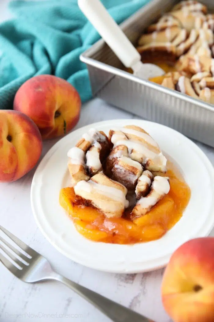 Fresh peach pie filling topped with a cinnamon roll and cream cheese frosting.