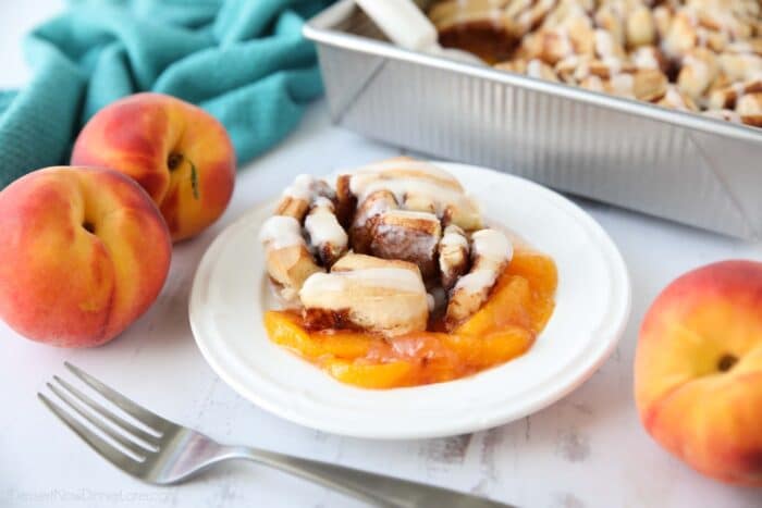 Начинка для пирога зі свіжих персиків, покрита булочкою з корицею та глазур’ю з вершкового сиру.