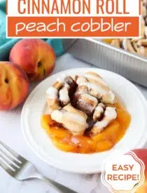 Labeled photo of Cinnamon Roll Peach Cobbler for Pinterest.