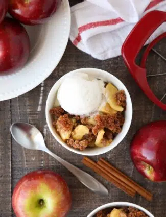 Bowl-full of apple brown betty topped with vanilla ice cream.