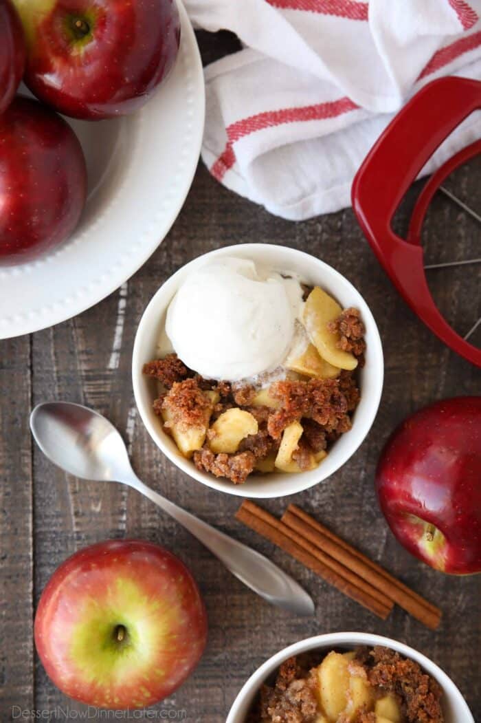 Zdjela puna smeđe betty jabuke prelivene sladoledom od vanilije.