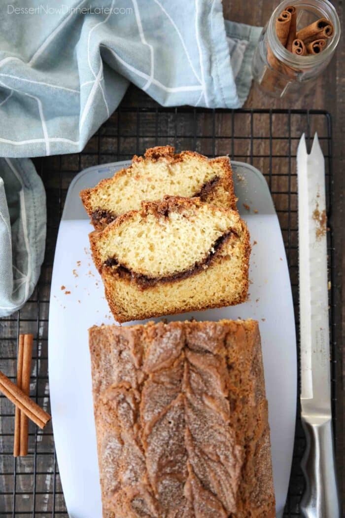 Top view of cinnamon quick bread being sliced on a cutting board.
