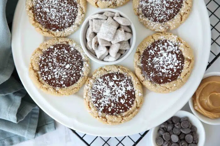 A plate of peanut butter cookies topped with chocolate and powdered sugar.