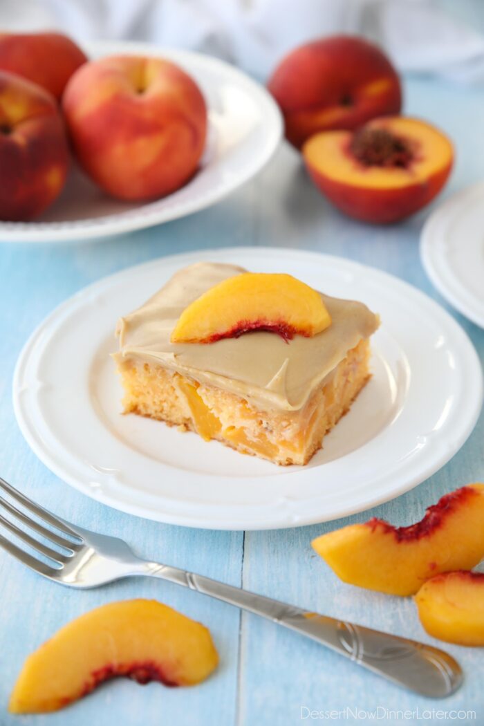 Квадратний шматок персикового торта з коричневою цукровою глазур’ю на тарілці.