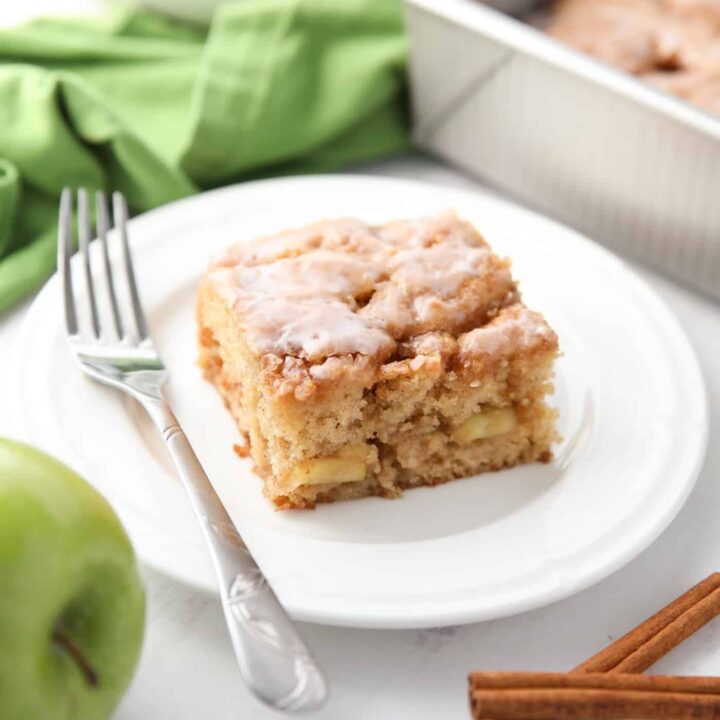 Square piece of glazed apple fritter cake on a plate.