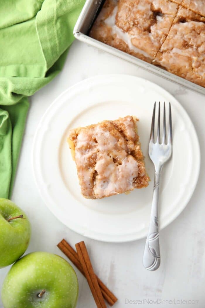Skats no augšas uz glazētu ābolu kanēļa kūku uz šķīvja.
