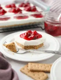 Slice of Cherry Delight on a plate with a fork-full taken out.