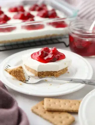 Slice of Cherry Delight on a plate with a fork-full taken out.