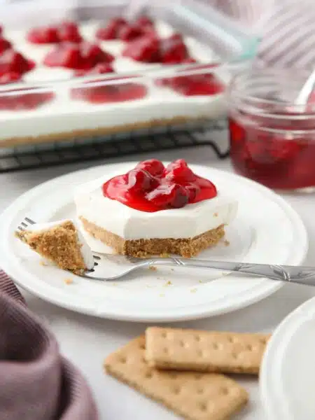 Slice of Cherry Delight on a plate with a fork-full taken out.