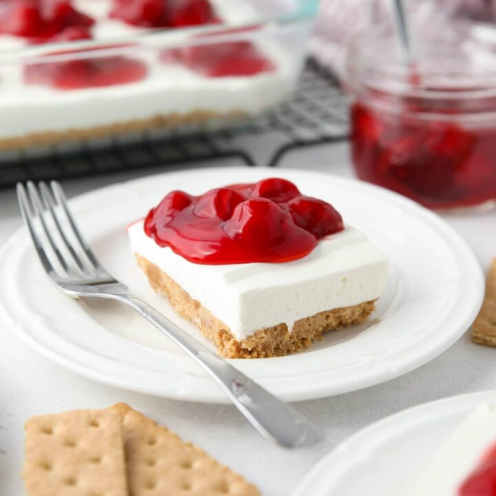 Slice of cherry delight no bake cheesecake on a plate.