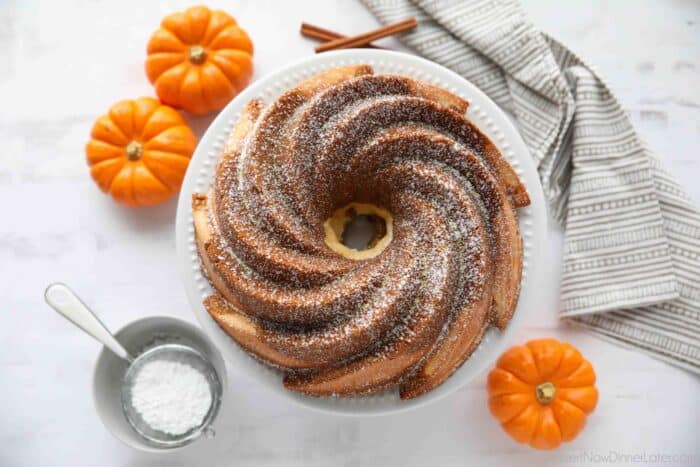 Baked Pumpkin Cream Cheese Bundt Cake on a plate with powdered sugar sprinkled on top.