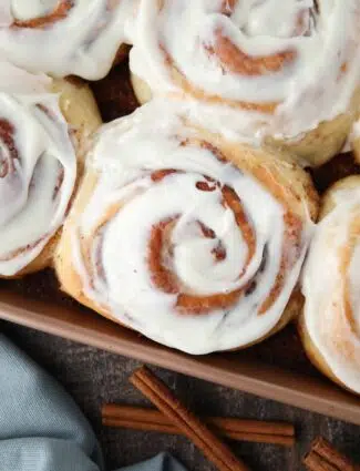 Close-up of the best cinnamon rolls with cream cheese frosting in pan.