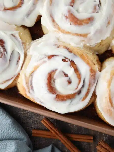 Close-up of the best cinnamon rolls with cream cheese frosting in pan.