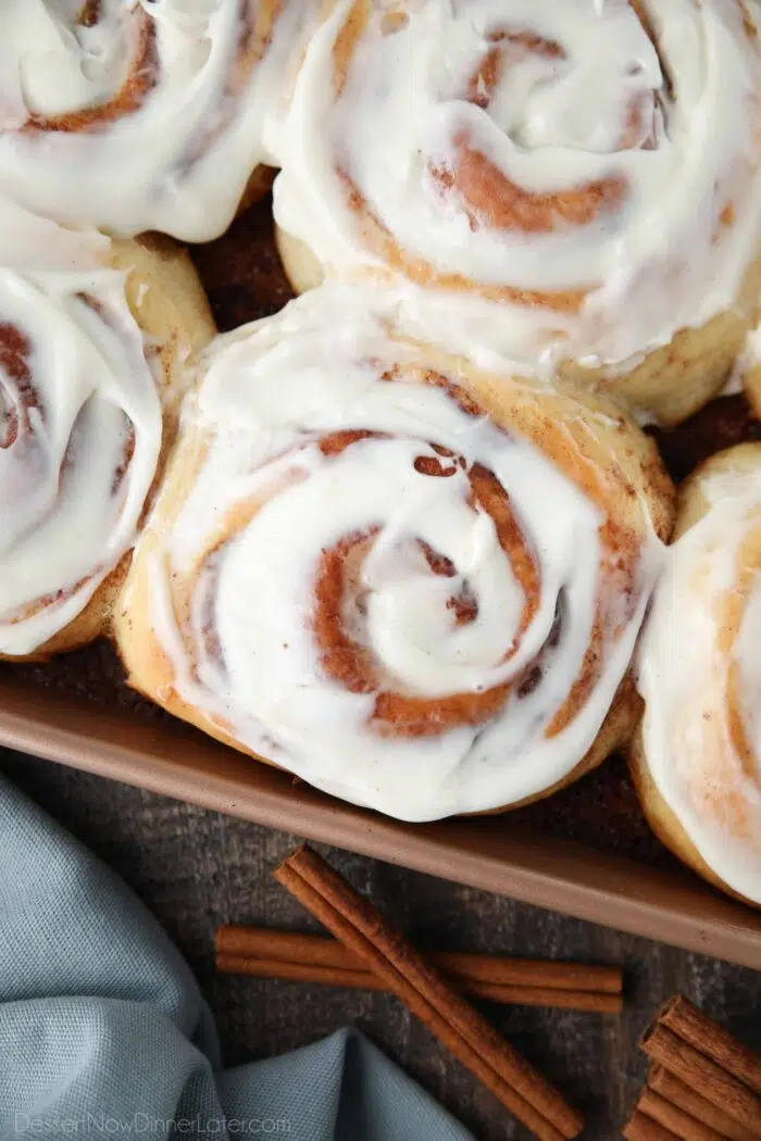 Close-up of the best cinnamon rolls with cream cheese frosting in pan.