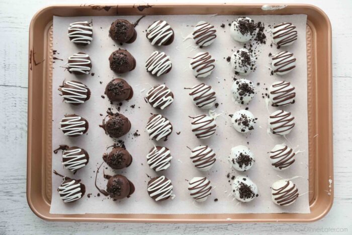 Chocolate dipped Oreo Balls on parchment paper.