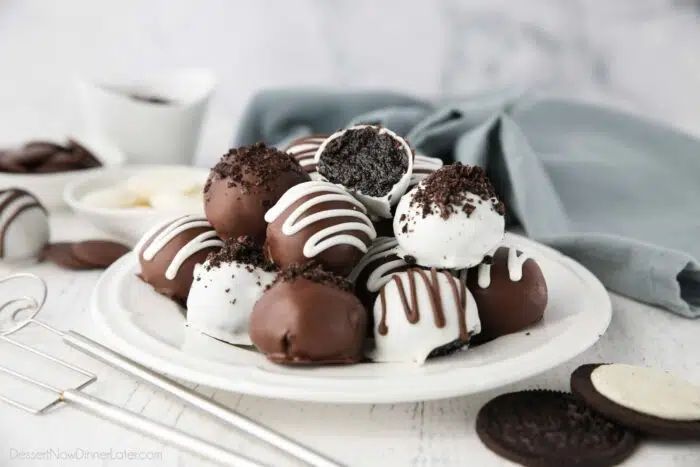 Oreo Balls on a plate with one cut open showing the inside.