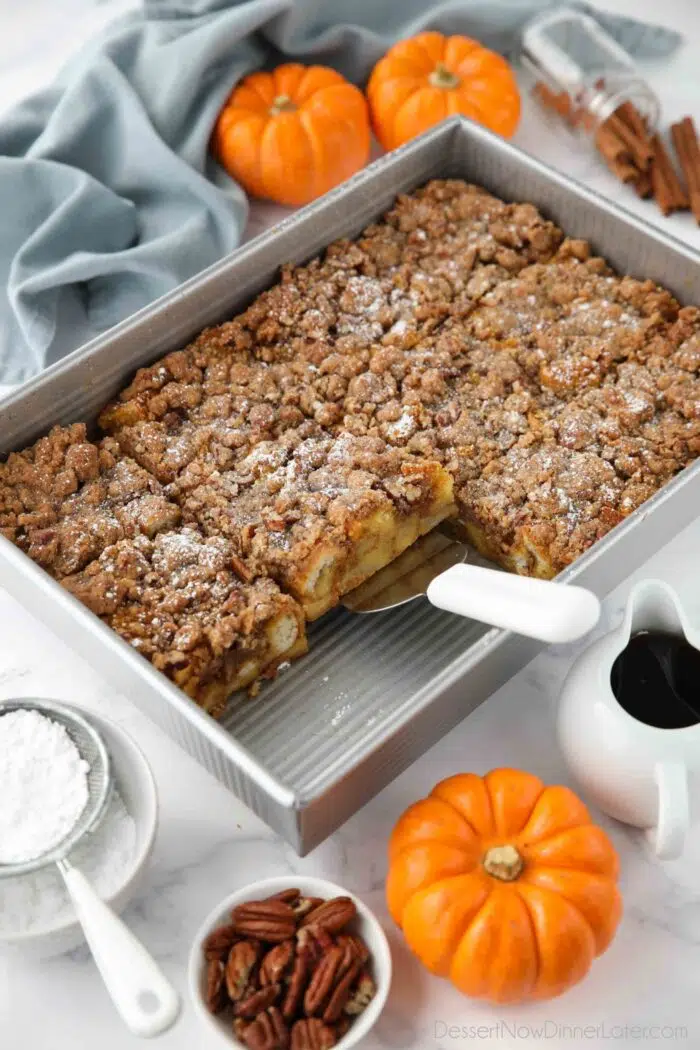 Pumpkin French Toast Casserole in a pan with a serving spatula.