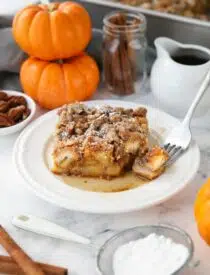 Piece of baked pumpkin French toast with a fork-full taken out.