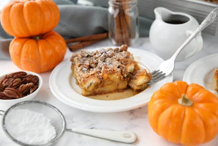 Piece of baked pumpkin French toast with a fork-full taken out.