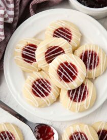 Top view of plate of raspberry thumbprint cookies with icing drizzle.