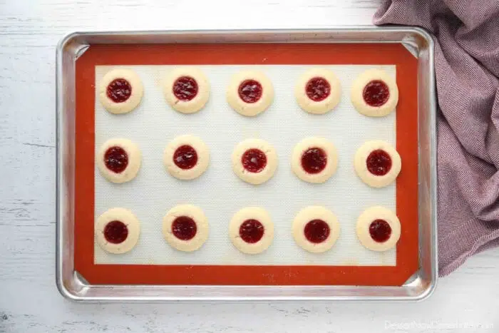 Baked raspberry thumbprint cookies on a tray.