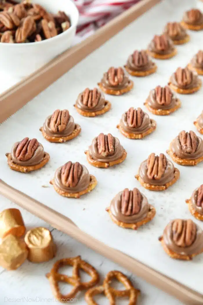 Rolo Pretzel Turtles on a baking sheet.