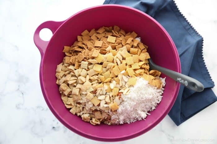 Bowl with rice and corn Chex cereals, Golden Grahams, sliced almonds, and sweetened coconut flakes.