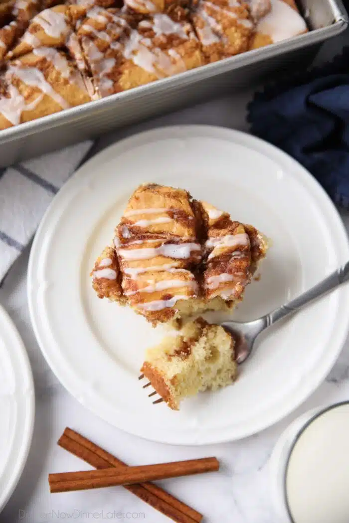 Fork full of cinnamon roll cake ready to be eaten.