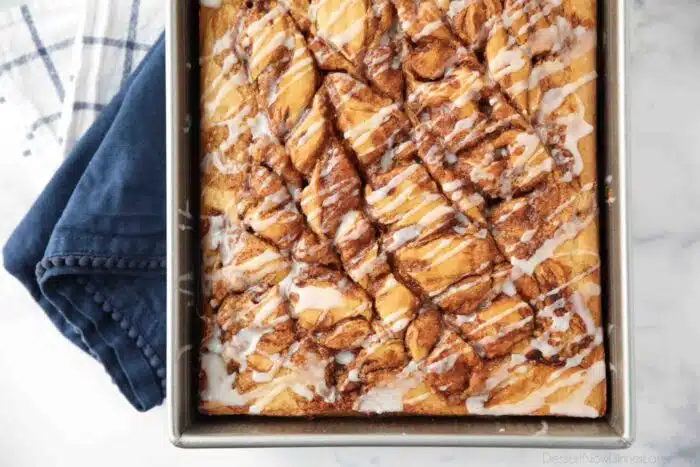 Top view of swirled cinnamon roll cake with a vanilla glaze drizzled over the top.