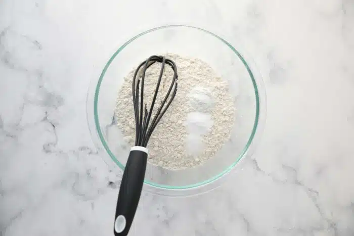 Dry ingredients in a bowl with a whisk.