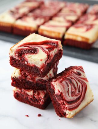 A stack of swirled Red Velvet Cheesecake Brownies.