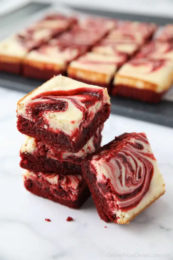 A stack of swirled Red Velvet Cheesecake Brownies.