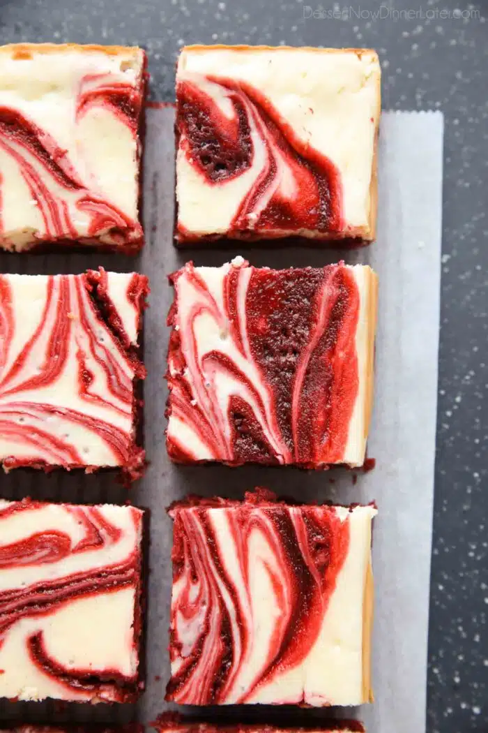 Swirled red velvet cheesecake brownies cut into squares.