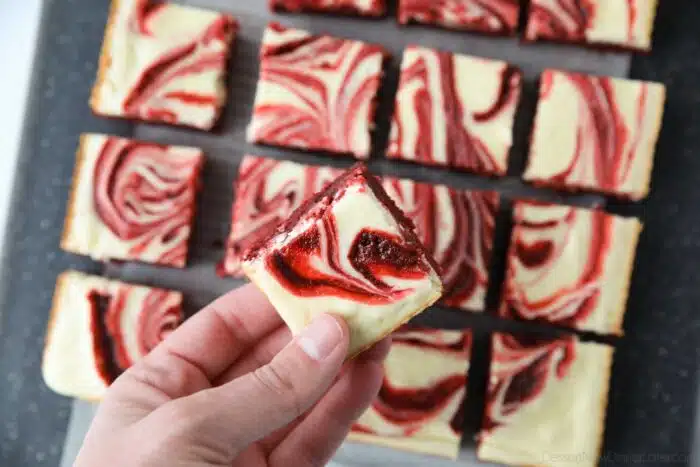 Holding a red velvet cream cheese brownies showing off the swirled top.