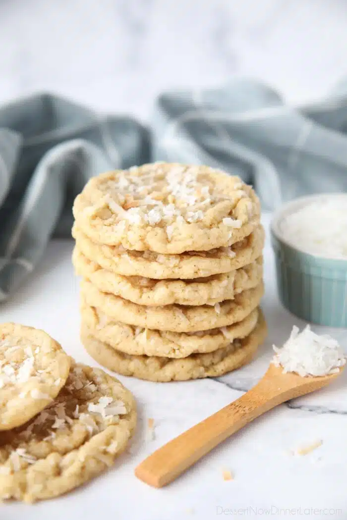 A stack of soft and chewy coconut cookies with extra shredded coconut on top.