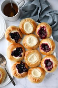 Variety of fruit and cream cheese kolaches on a platter.