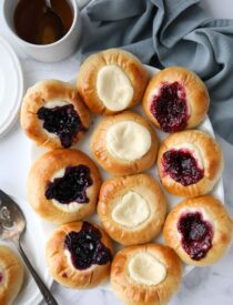 Variety of fruit and cream cheese kolaches on a platter.