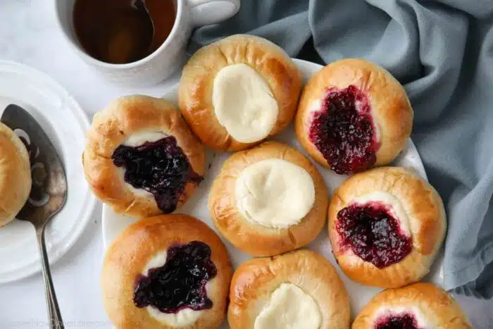 Variety of fruit and cream cheese kolaches on a platter.