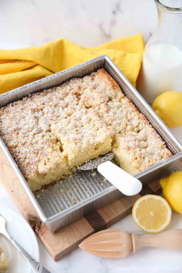 Lemon coffee cake in pan with crumb topping dusted with powdered sugar.