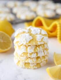 Stack of lemon crinkle cookies with powdered sugar on the outside.