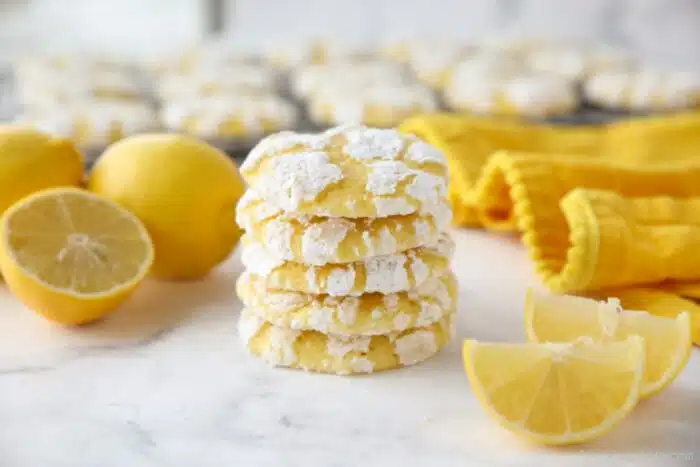 Stack of lemon crinkle cookies with powdered sugar on the outside.