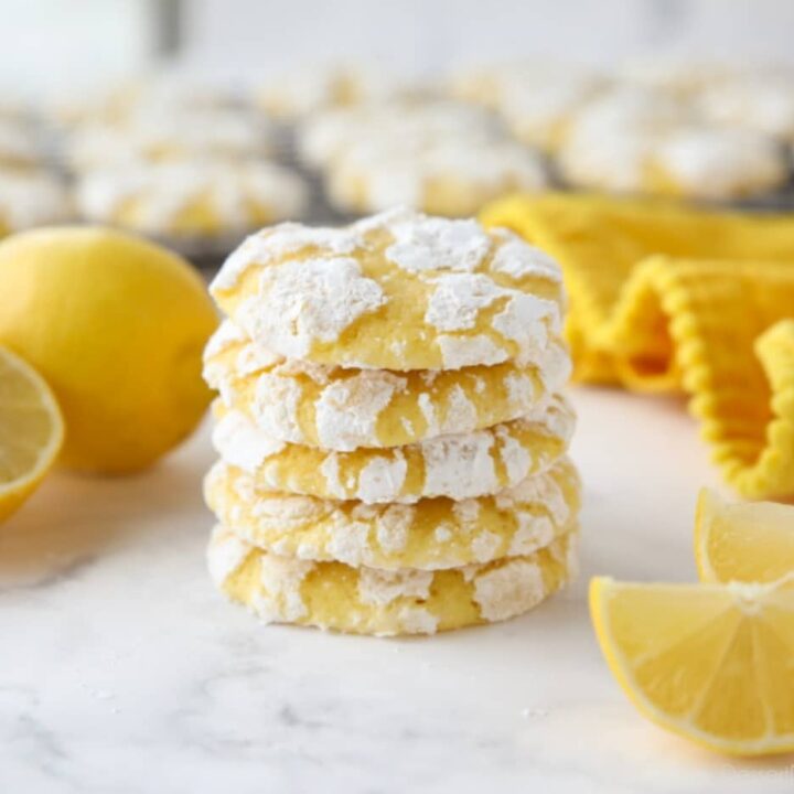Stack of lemon crinkle cookies with powdered sugar on the outside.