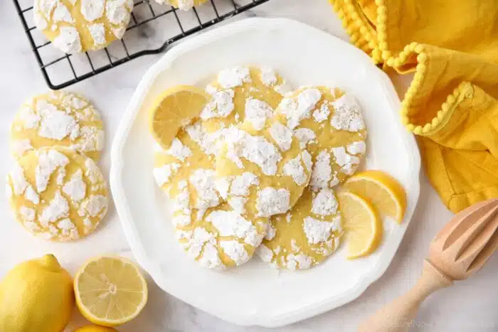 Plate of lemon crinkle cookies with lemon wedges.