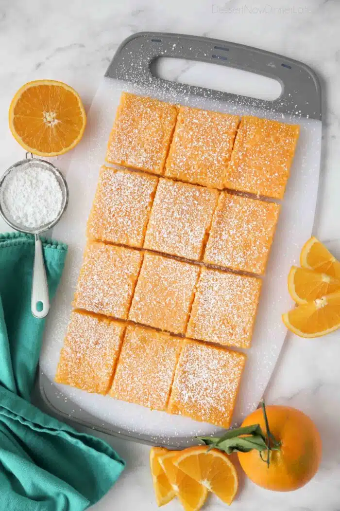 Top view of orange bars cut into squares on a cutting board.