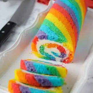 Rainbow Cake Roll with colored cake stripes and vanilla buttercream filling.