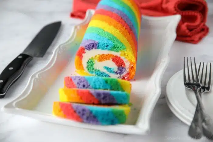Rainbow Cake Roll with colored cake stripes and vanilla buttercream filling.