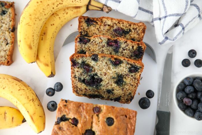 Blueberry banana bread with sour cream sliced on cutting board.